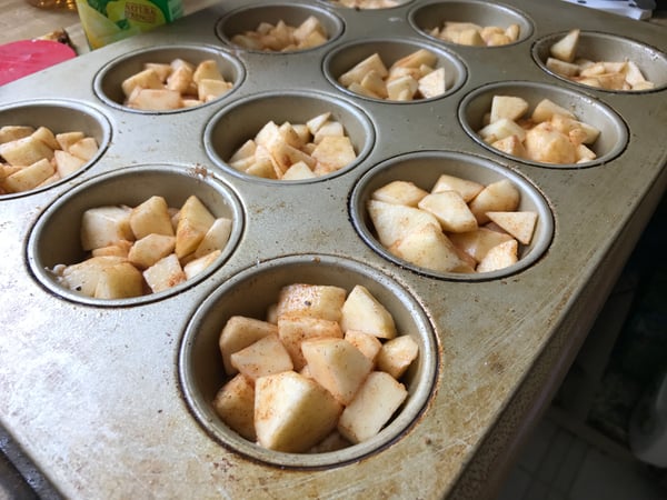 apples in muffin tin over batter