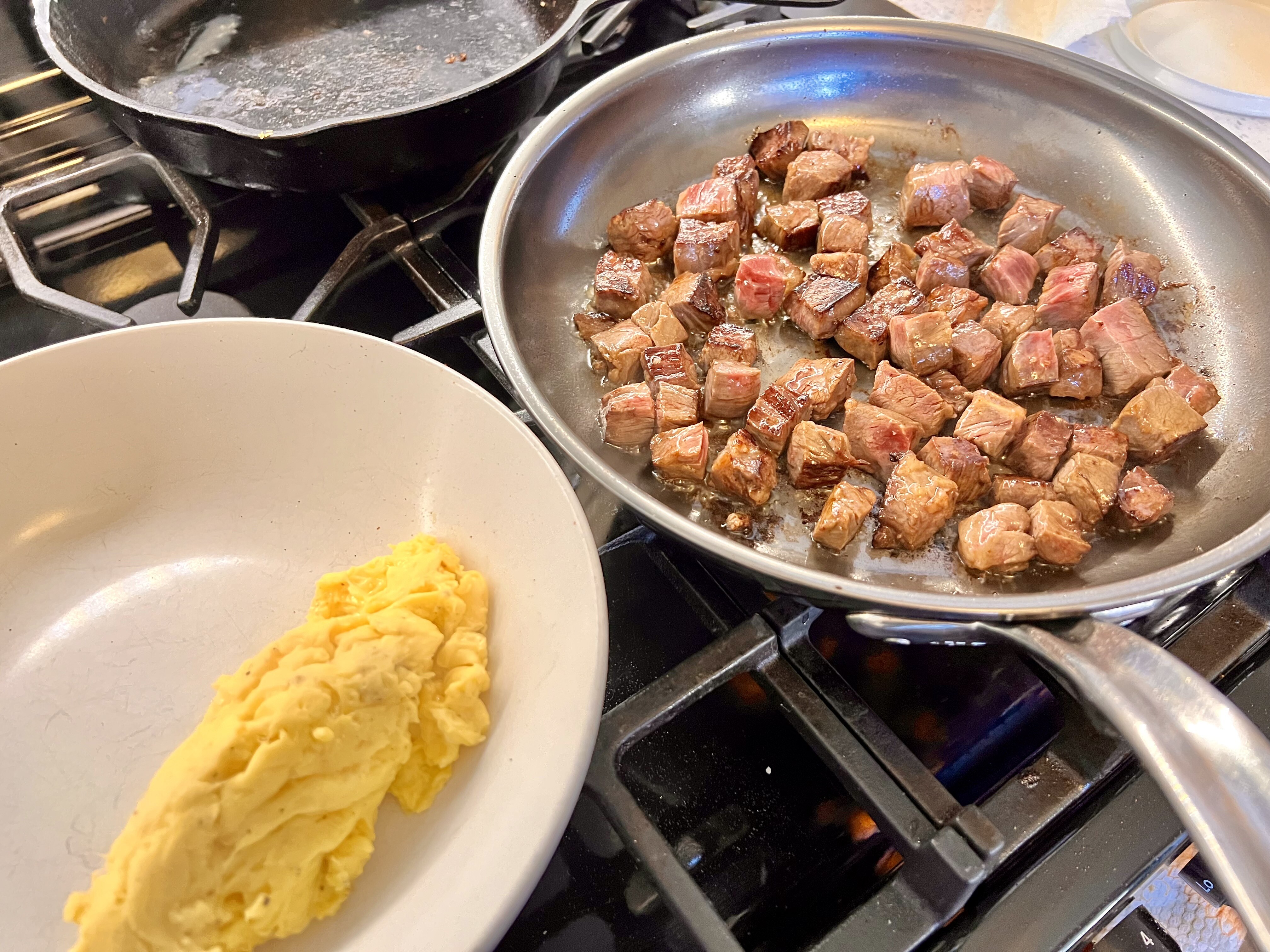 Steak in pan, eggs on plate