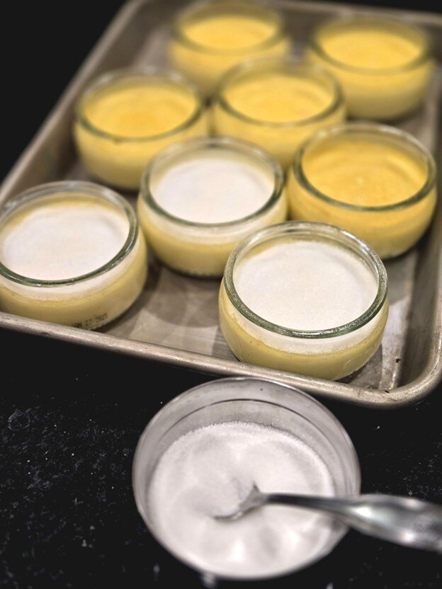 Pouring sugar on creme brulee