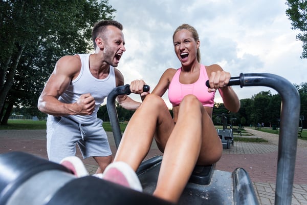 Motivated couple on the outdoor gym, horizontal