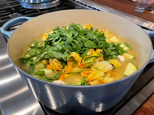 adding squash blossoms and spinach